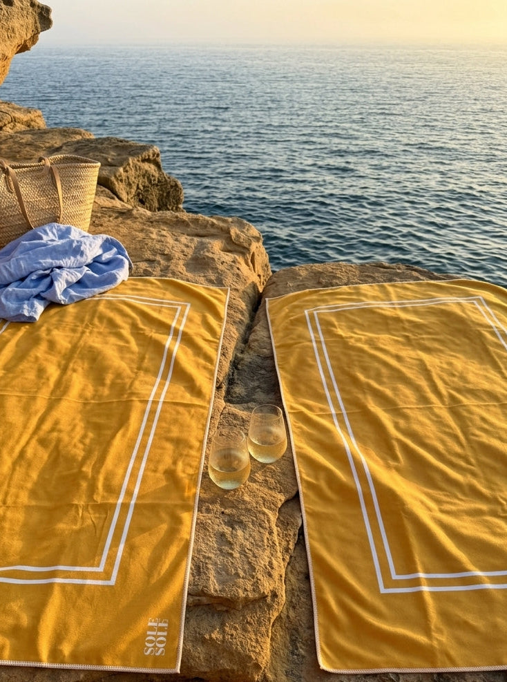 Capri microfiber towel placed on a cliff overlooking a sunset