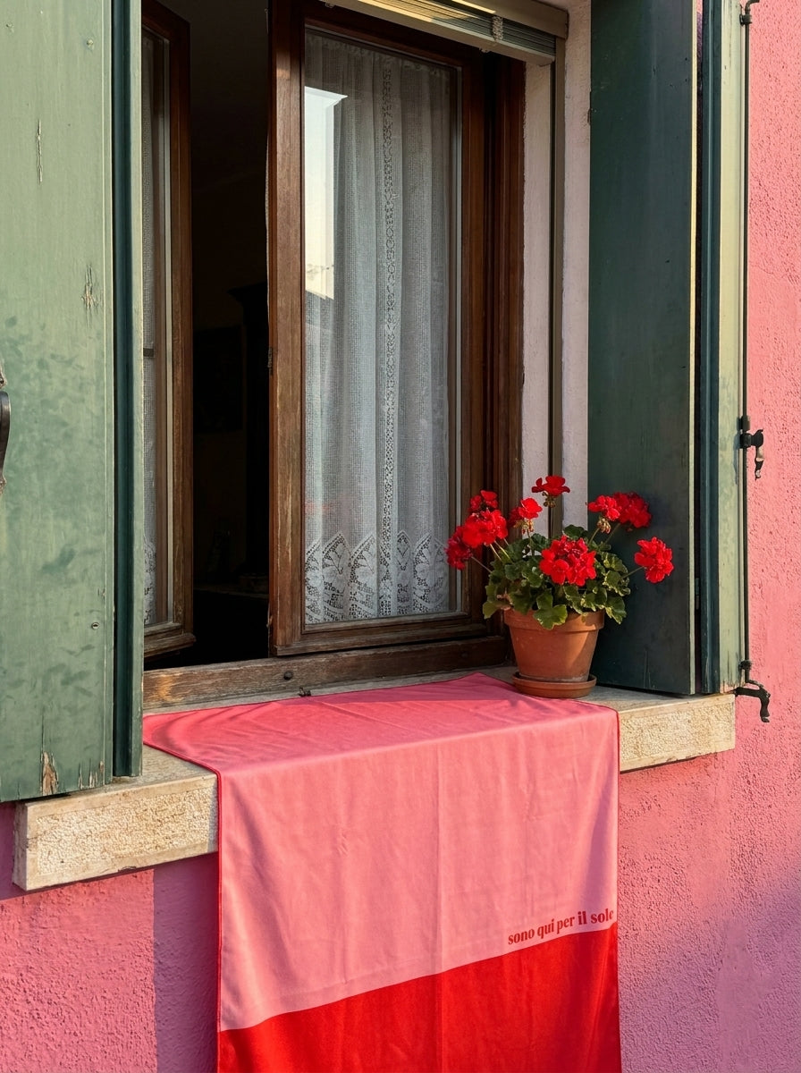 Salerno Travel Towel placed on a windowsill of an old Italian building