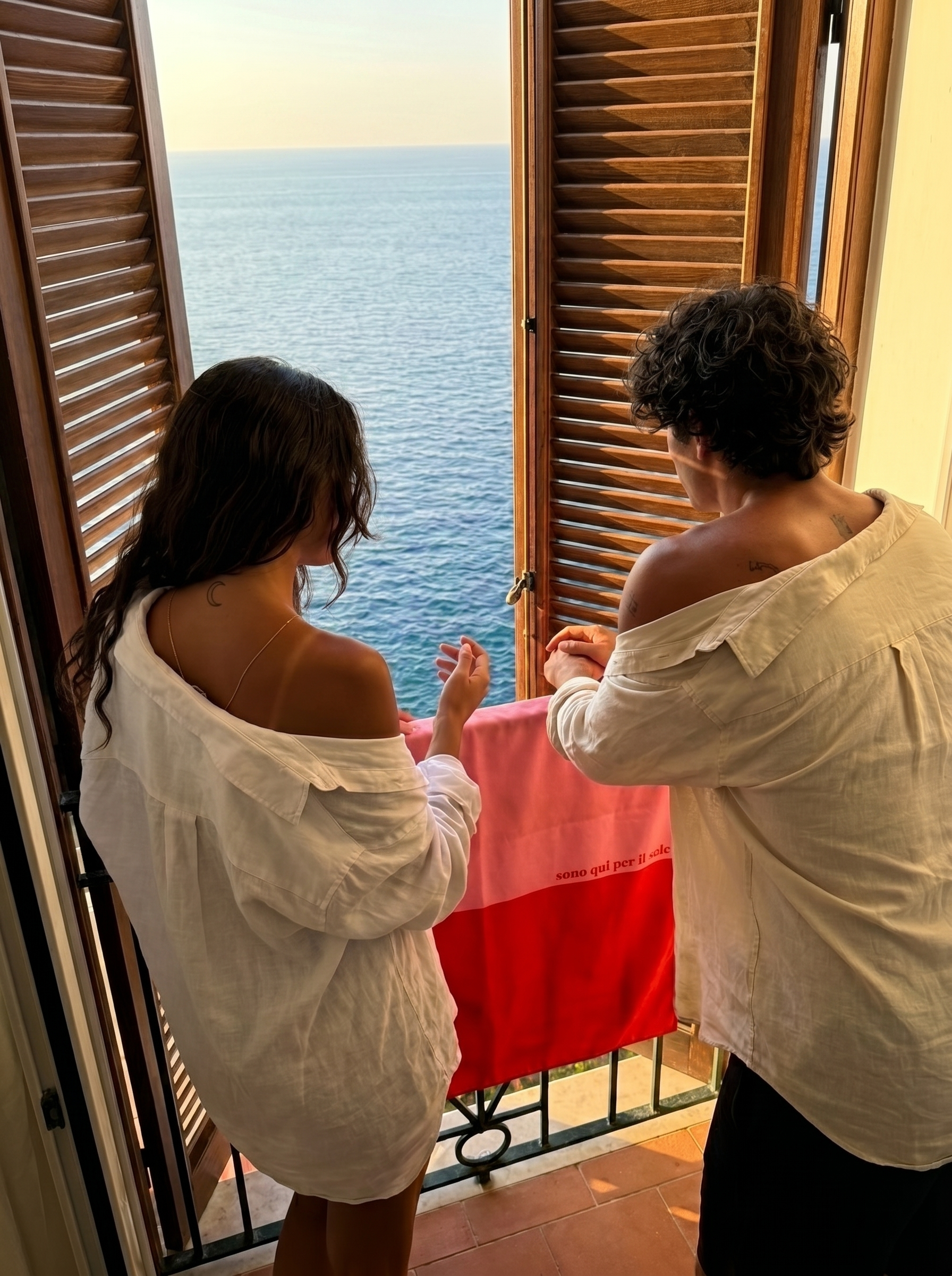Salerno Travel Towel hanging over a balcony railing with a scenic view